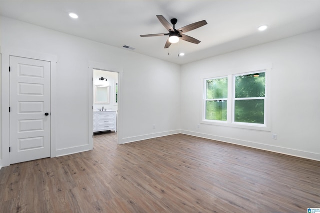 unfurnished bedroom featuring sink, dark wood-type flooring, connected bathroom, and ceiling fan