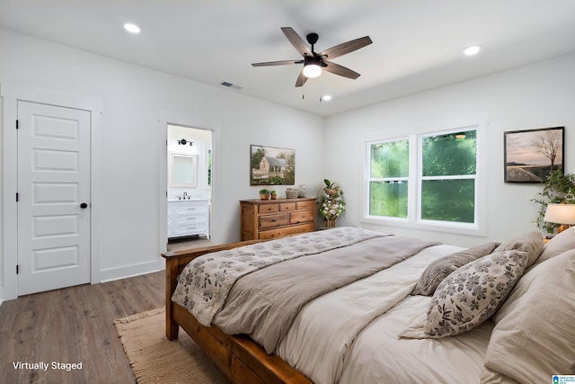 bedroom with connected bathroom, sink, hardwood / wood-style floors, and ceiling fan