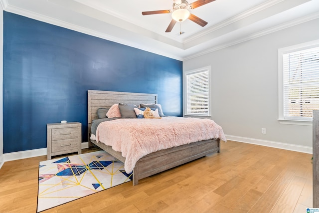 bedroom featuring hardwood / wood-style floors, ceiling fan, and crown molding