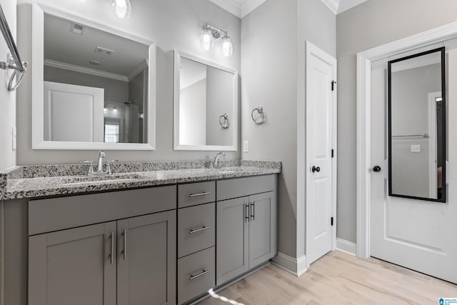 bathroom with vanity, wood-type flooring, crown molding, and walk in shower