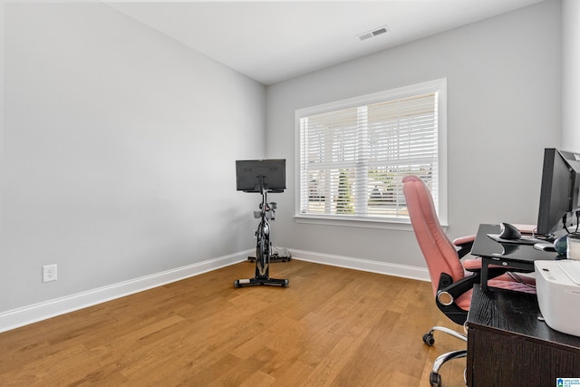 home office with light hardwood / wood-style floors