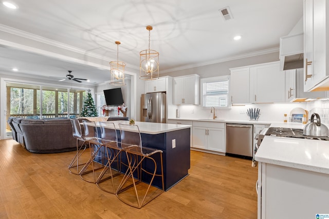 3087 Simms Lndg, Pelham, AL 35124 - kitchen featuring appliances with stainless steel finishes, a kitchen breakfast bar, open floor plan, a center island, and ornamental molding