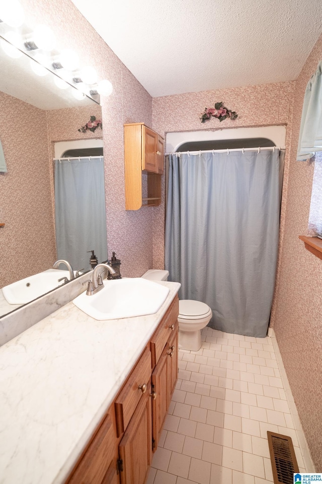 bathroom with tile patterned floors, a textured ceiling, toilet, vanity, and a shower with shower curtain