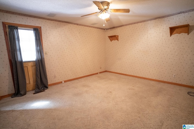 unfurnished room featuring carpet flooring, ceiling fan, ornamental molding, and a textured ceiling