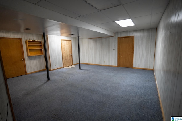 basement featuring a paneled ceiling and light colored carpet