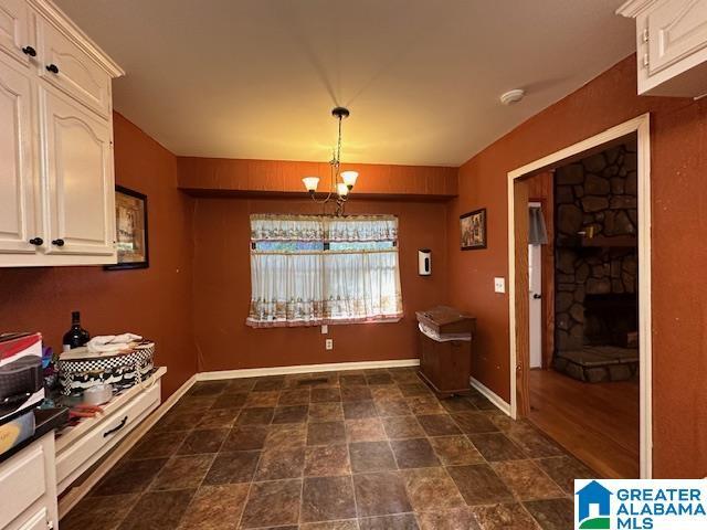 interior space with a fireplace, hanging light fixtures, and a chandelier