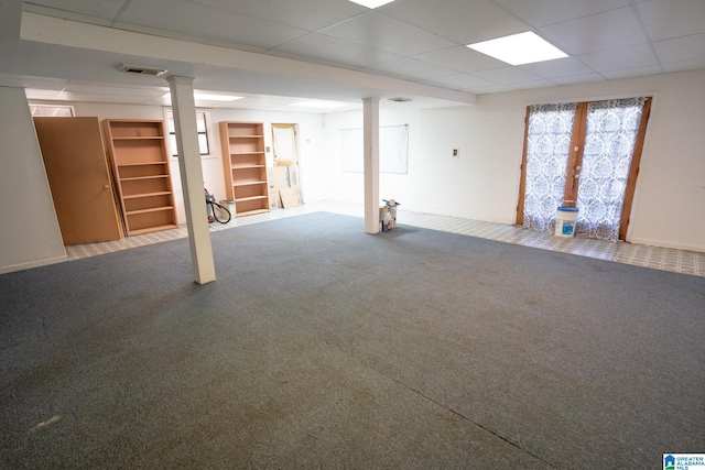 basement featuring carpet flooring and a paneled ceiling