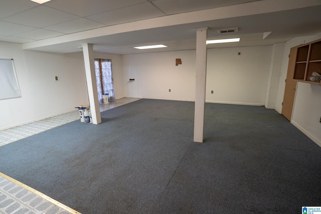 basement with dark colored carpet and a paneled ceiling