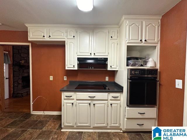 kitchen with white cabinets, oven, and cooktop