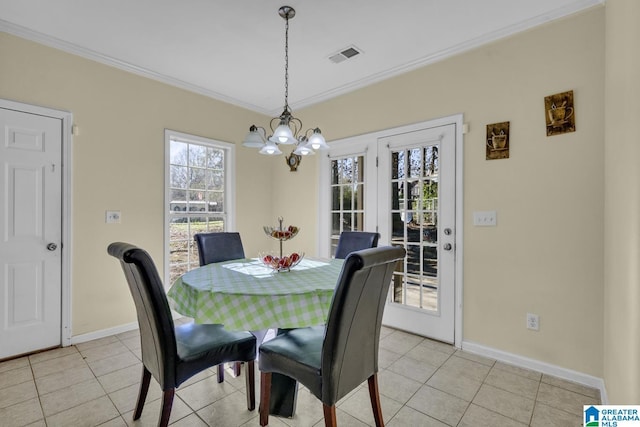 dining space with an inviting chandelier, ornamental molding, and light tile patterned flooring