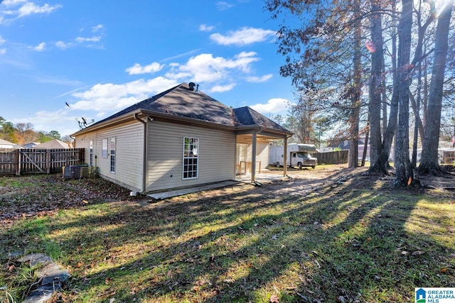 rear view of property featuring a lawn and central AC