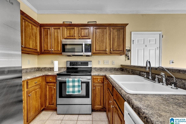 kitchen with light tile patterned flooring, ornamental molding, sink, and appliances with stainless steel finishes