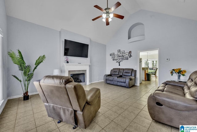 living room featuring ceiling fan, a fireplace, light tile patterned floors, and high vaulted ceiling