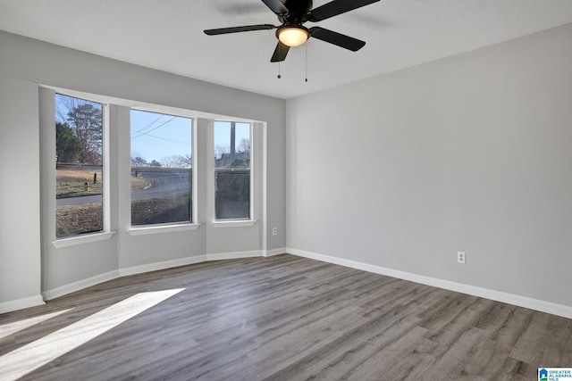 spare room featuring hardwood / wood-style floors, a textured ceiling, ceiling fan, and a healthy amount of sunlight