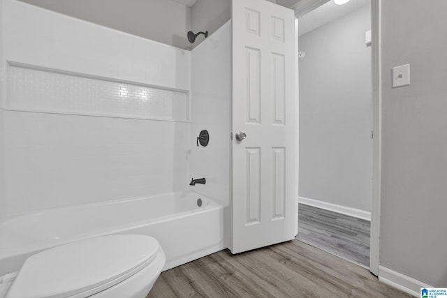 bathroom featuring wood-type flooring, a textured ceiling, shower / bath combination, and toilet