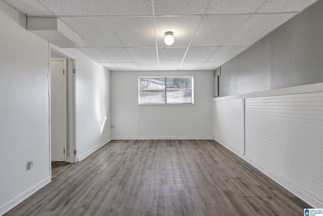 spare room with a paneled ceiling and hardwood / wood-style floors