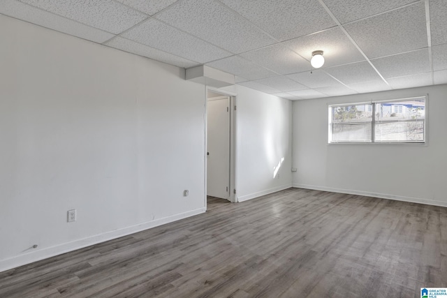 empty room with hardwood / wood-style flooring and a drop ceiling