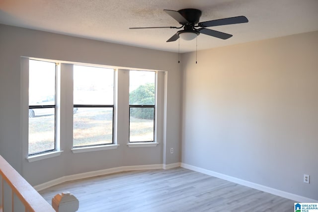 unfurnished room featuring ceiling fan, light hardwood / wood-style flooring, and a textured ceiling