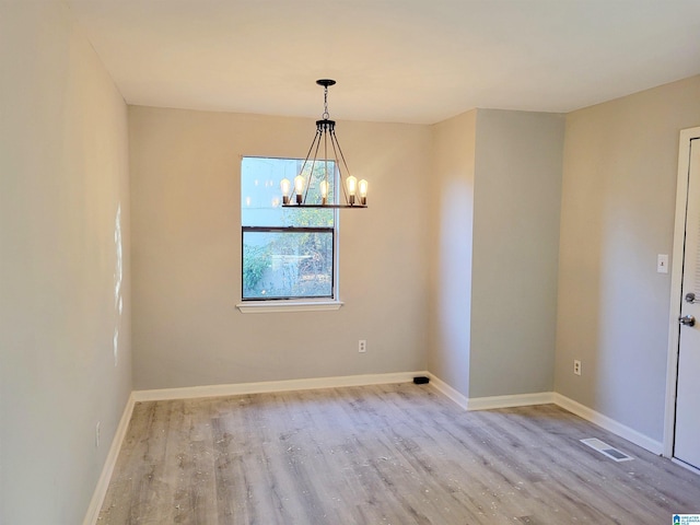 unfurnished dining area with light hardwood / wood-style floors and a notable chandelier