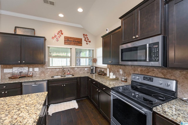 kitchen with decorative backsplash, sink, vaulted ceiling, and appliances with stainless steel finishes