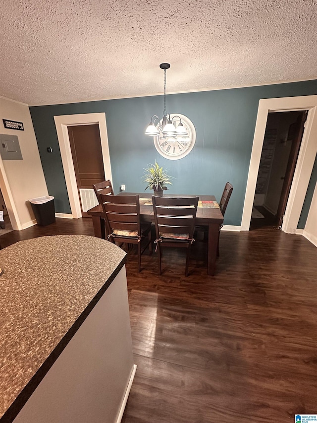 dining room with dark hardwood / wood-style flooring, a textured ceiling, and a chandelier