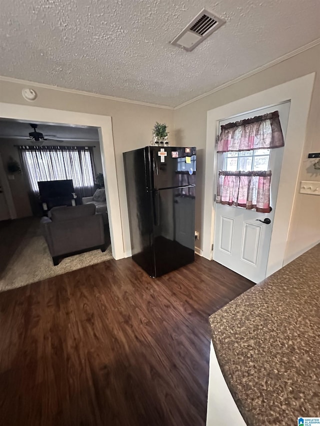 entryway featuring dark hardwood / wood-style floors, ceiling fan, ornamental molding, and a textured ceiling