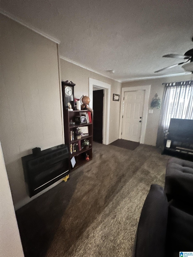 living room featuring ceiling fan, carpet, and a textured ceiling