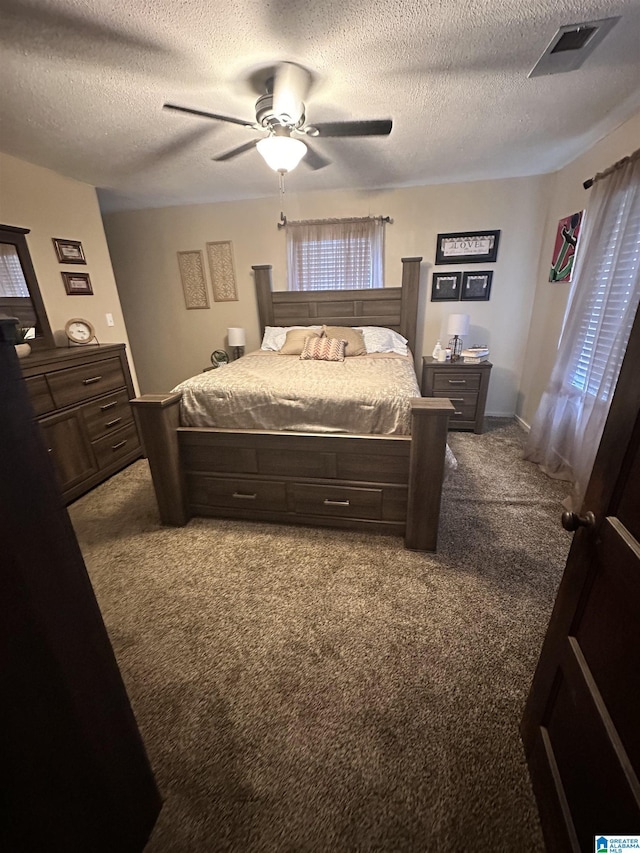 bedroom with ceiling fan, carpet, and a textured ceiling