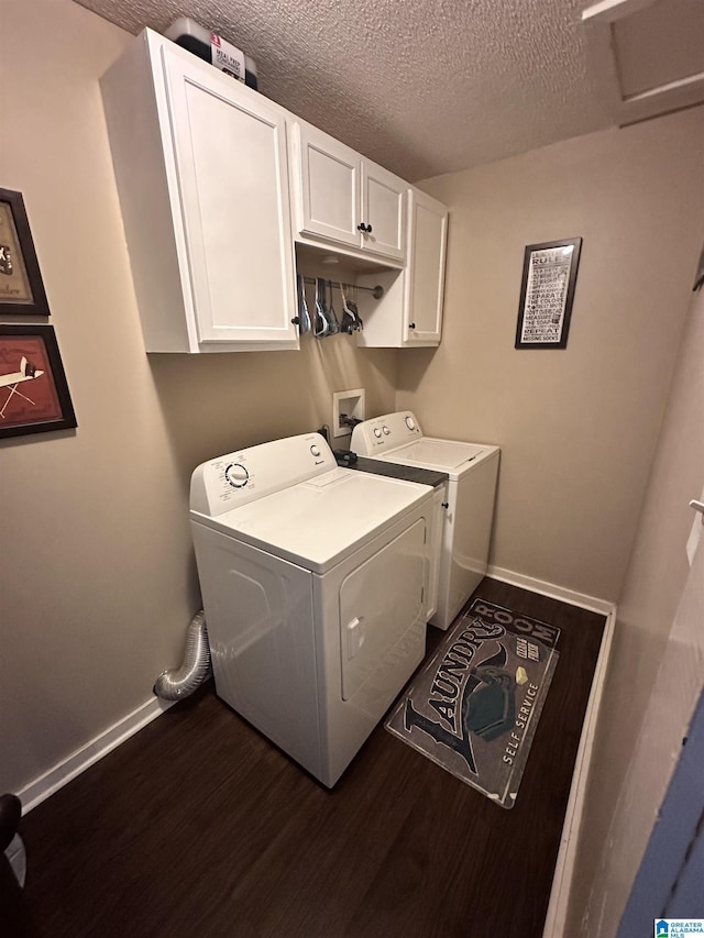 laundry area with cabinets, dark hardwood / wood-style flooring, washer and dryer, and a textured ceiling