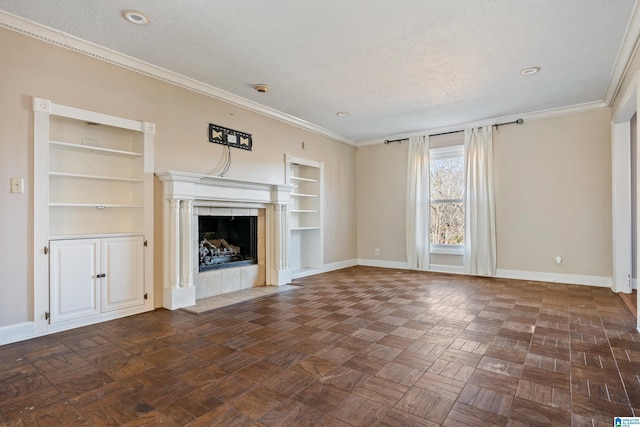 unfurnished living room featuring a tiled fireplace, built in features, a textured ceiling, and ornamental molding