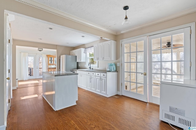 kitchen with white cabinets, french doors, stainless steel refrigerator, and plenty of natural light