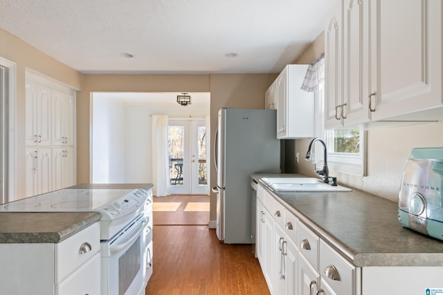 kitchen with white cabinets, white electric range oven, a healthy amount of sunlight, and french doors