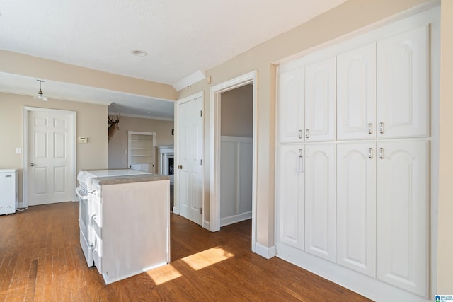 kitchen with white range, ceiling fan, a textured ceiling, dark hardwood / wood-style flooring, and white cabinetry