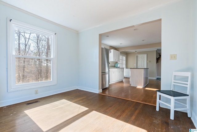 unfurnished living room with dark hardwood / wood-style floors and ornamental molding