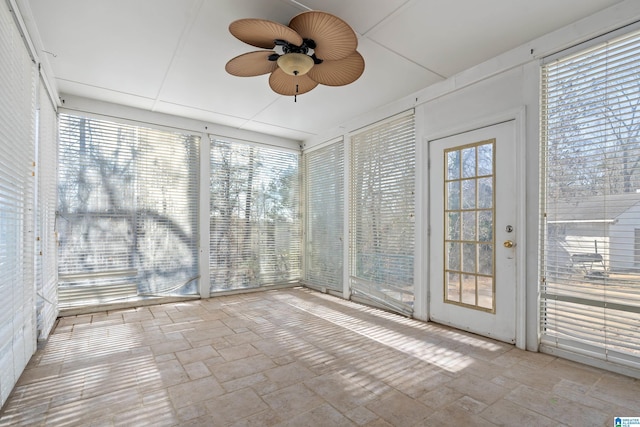 unfurnished sunroom featuring ceiling fan