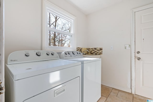 laundry room with washing machine and dryer, light tile patterned floors, and sink