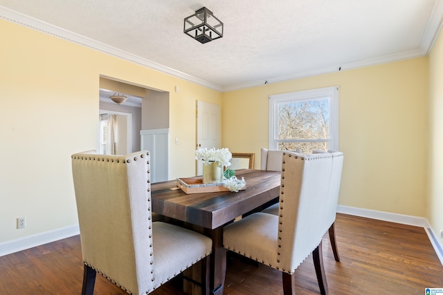 dining space featuring dark hardwood / wood-style flooring, a textured ceiling, and ornamental molding