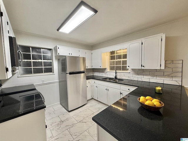 kitchen with stainless steel fridge, sink, and white cabinets