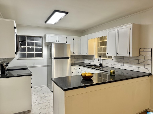 kitchen with stainless steel refrigerator, white cabinetry, sink, kitchen peninsula, and crown molding