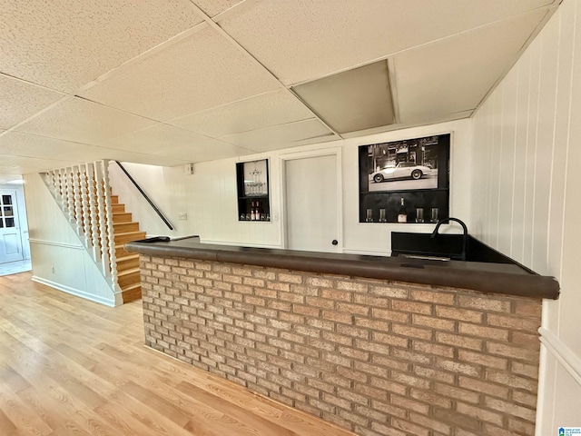 bar featuring a drop ceiling, wood-type flooring, and sink