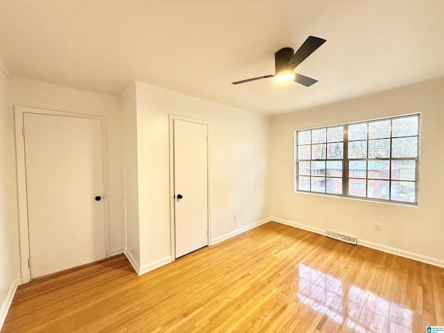 unfurnished bedroom featuring ceiling fan, crown molding, and light hardwood / wood-style flooring