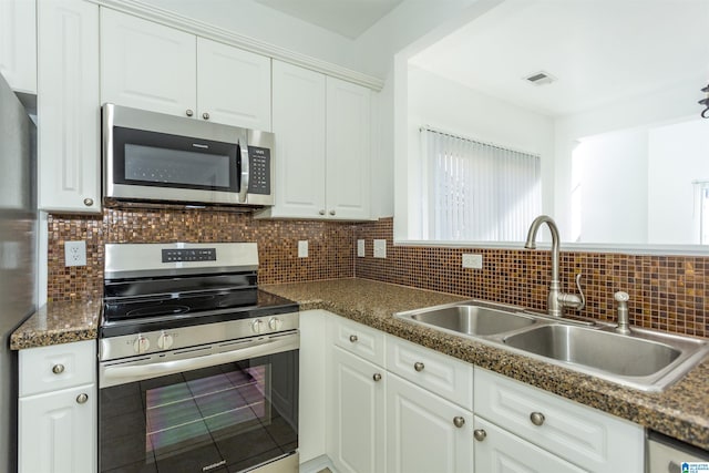 kitchen with white cabinets, decorative backsplash, sink, and appliances with stainless steel finishes