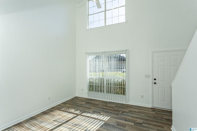 entryway featuring ceiling fan, a towering ceiling, a healthy amount of sunlight, and dark hardwood / wood-style floors