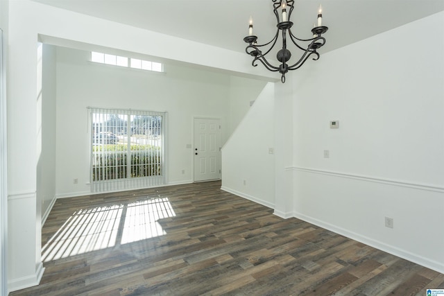 unfurnished dining area with a chandelier and dark wood-type flooring