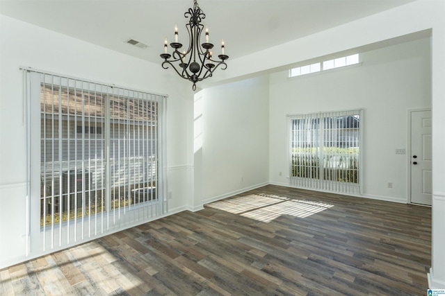 unfurnished dining area featuring dark hardwood / wood-style floors and an inviting chandelier