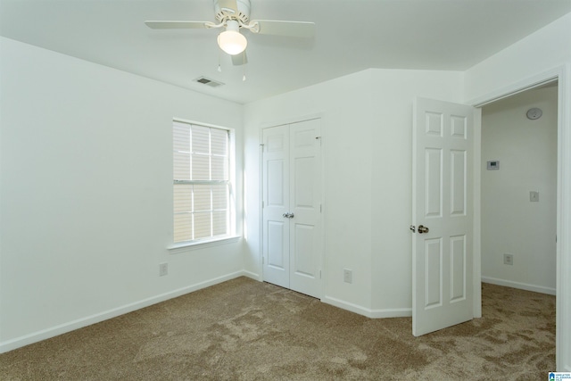 unfurnished bedroom with ceiling fan, a closet, and light colored carpet