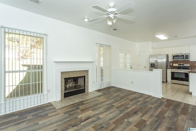 unfurnished living room featuring ceiling fan, a fireplace, and hardwood / wood-style flooring