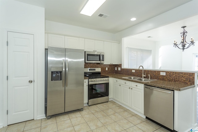 kitchen with white cabinets, appliances with stainless steel finishes, a chandelier, and sink