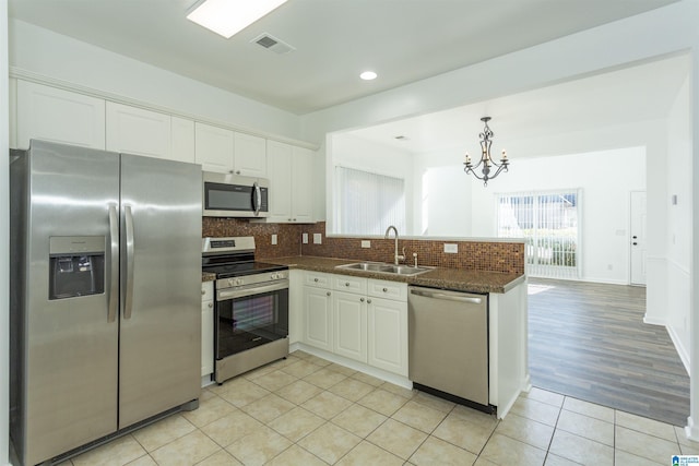 kitchen with sink, white cabinets, light hardwood / wood-style floors, and appliances with stainless steel finishes