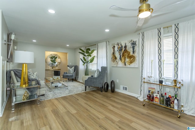 sitting room with ceiling fan and light wood-type flooring